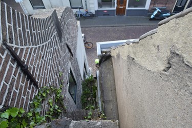 <p>Tussen het onderzochte huis Kamperstraat 36 en het een stukje terugliggende linker buurpand bleef een deel van de barbacanemuur bewaard, hier vanaf de bovenzijde gefotografeerd. </p>
